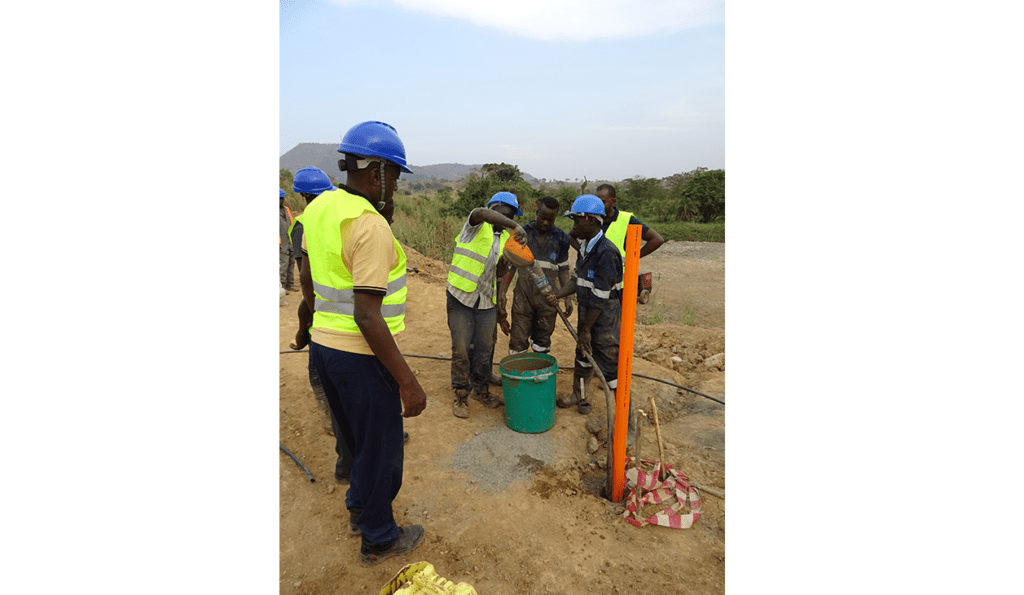 Team of Engineers placing grout around QJ inclinometer casing at Kabaale airport